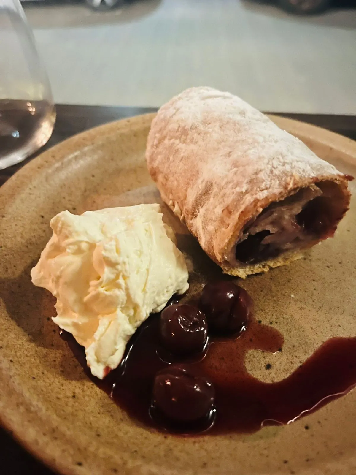 A slice of sour cherry strudel with whipped cream